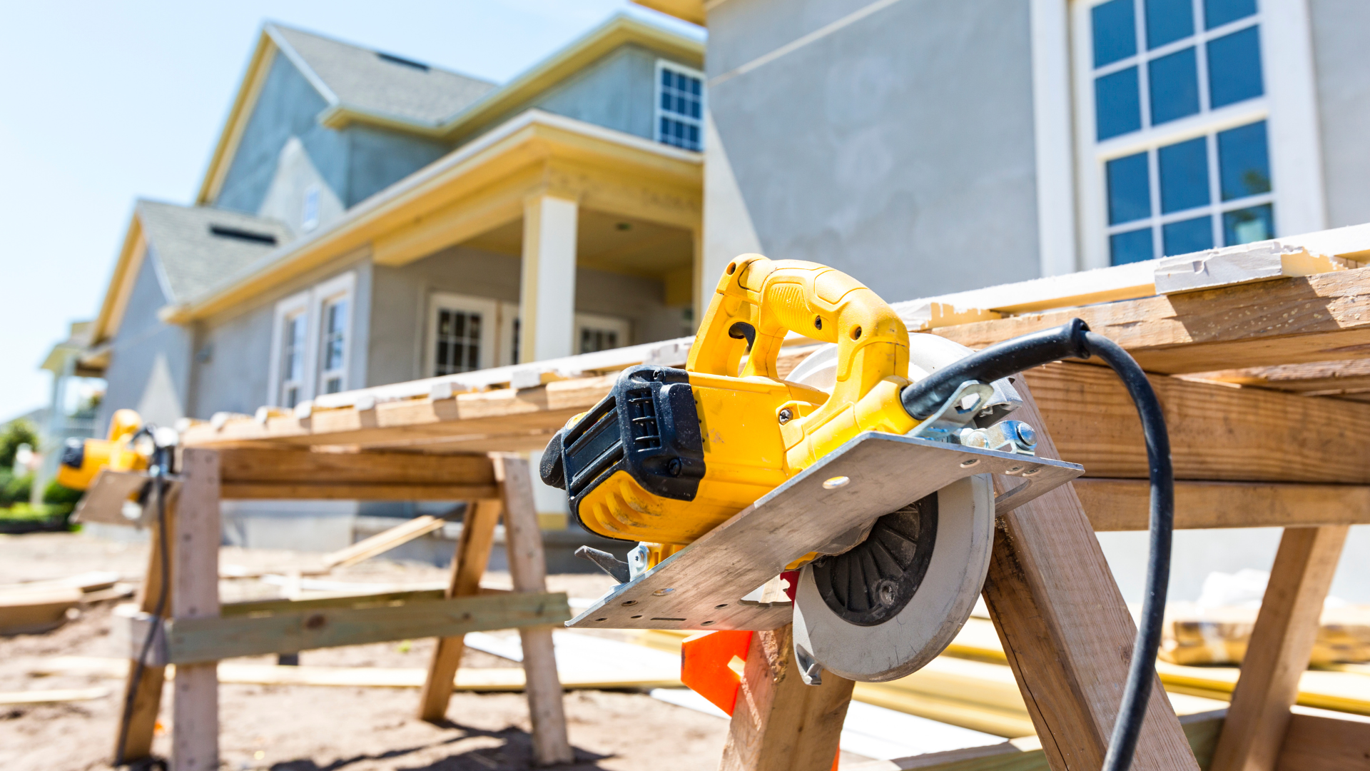 Wood-cutting saw in front of a partially built house, symbolizing construction work and the serious injuries that can occur on job sites, relating to BerkleyNet’s responsible management of workers compensation claims. 