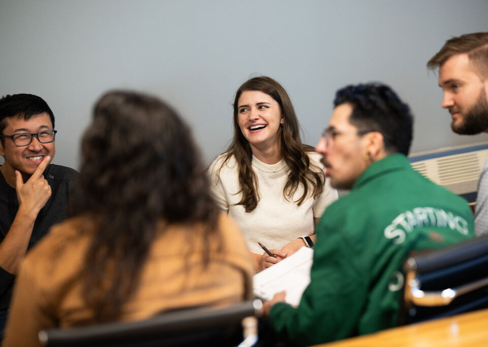 Group of BerkleyNet employees smiling in an office. 