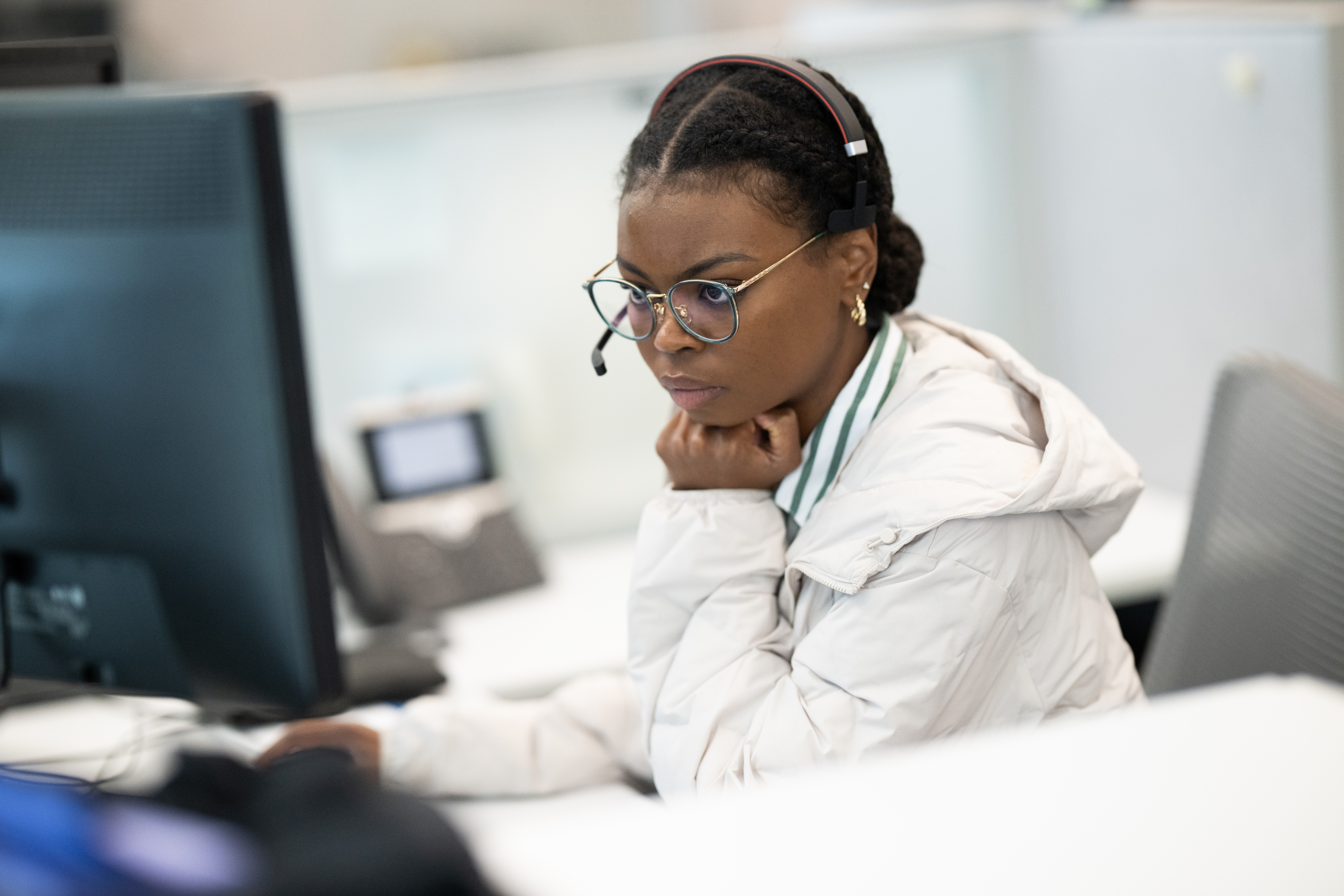 Two BerkleyNet employees at a desk listening in on workers compensation insurance meeting.    