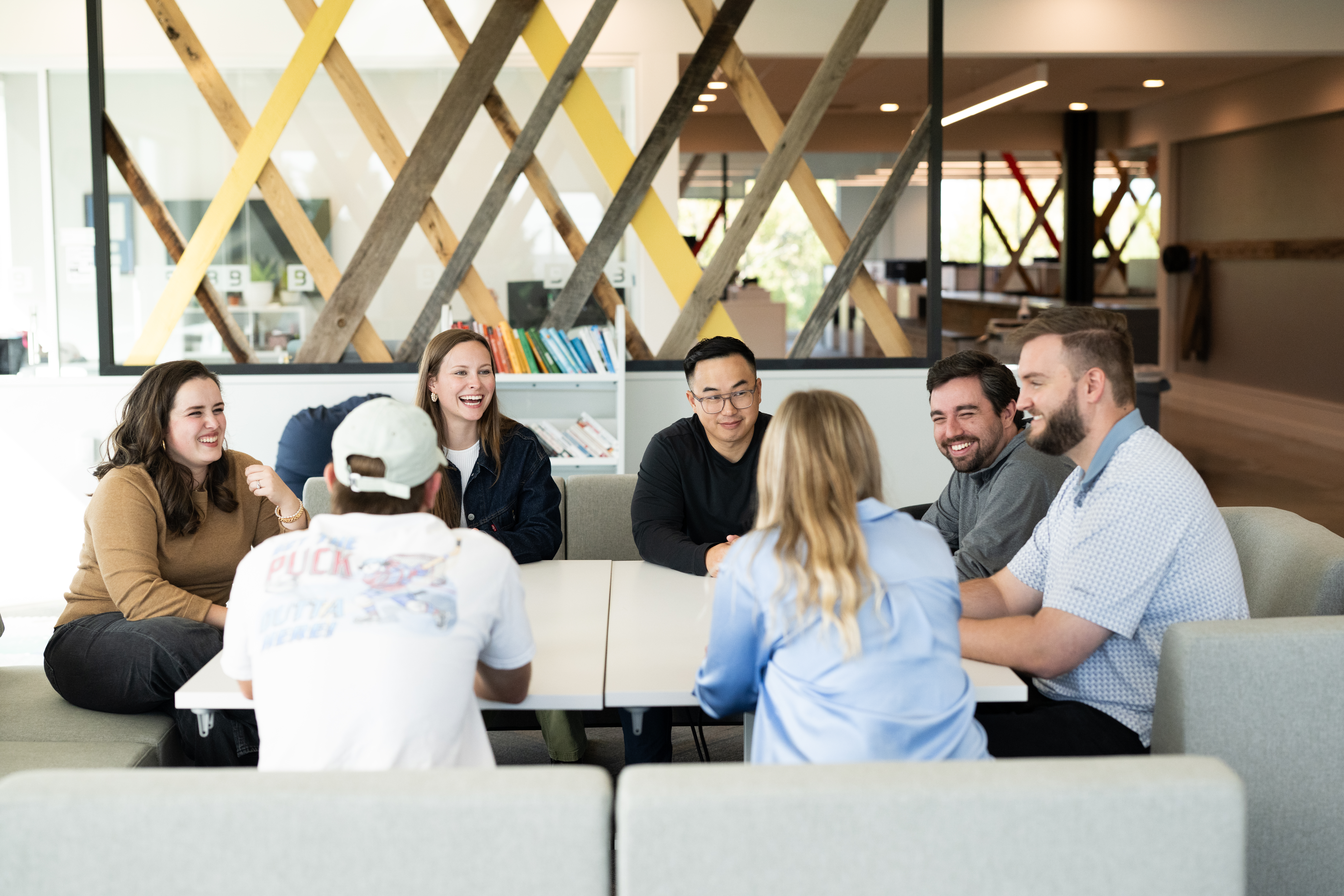 BerkleyNet employees in a hybrid meeting, two employees in the  office and three team members joining remotely via video call.  